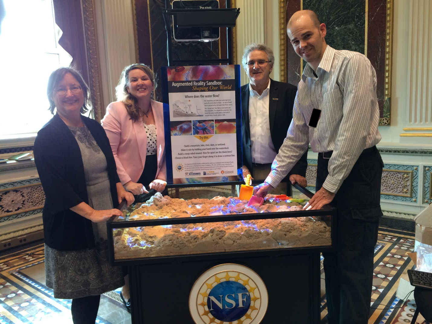 In the Eisenhower Executive Office Building during exhibition. Left to right: Dr. Louise H. Kellogg, Neysa Call (Legislative Aide & Grants Director for Senate Democratic Leader Harry Reid), Dr. Geoffrey Schladow, Dr. Oliver Kreylos. Photo credit: Terry Davies, National Science Foundation.